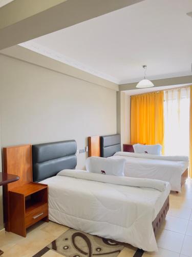 a bedroom with two beds and a window at LEYSHOF HOTEL in Mwanza