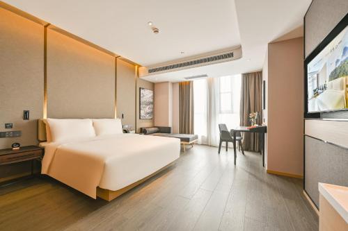 a hotel room with a white bed and a television at Atour Hotel Shanghai Songjiang Sports Center in Shanghai