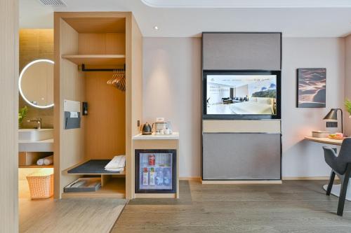 a kitchen with a refrigerator and a desk in a room at Atour Hotel Shanghai Songjiang Sports Center in Shanghai