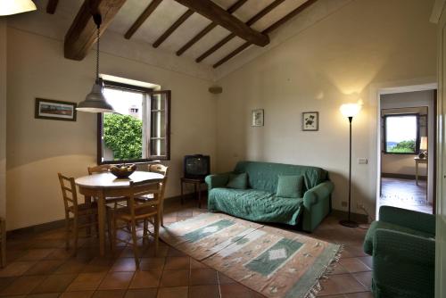 a living room with a green couch and a table at Podere Il Pino in Poggibonsi