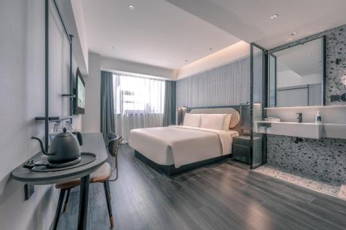 a hotel room with a bed and a sink at Atour Light Zhengzhou West Longhai Road Subway Station in Zhengzhou