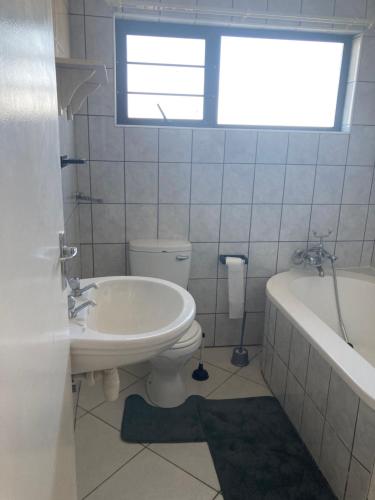 a bathroom with a toilet and a tub and a sink at Daffodil self catering and accommodation A in Swakopmund