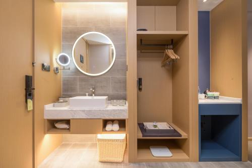 a bathroom with a sink and a mirror at Atour Hotel Nantong Jinsha in Nantong