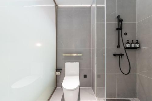 ein Badezimmer mit einem weißen WC und einer Dusche in der Unterkunft Atour X Hotel Yangzhou East Station Li Ning Sports Park in Yangzhou