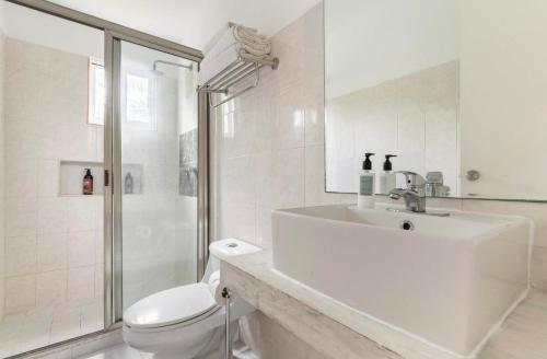 a white bathroom with a sink and a toilet at VISTA Departamento privado dos habitaciones Cancún in Cancún