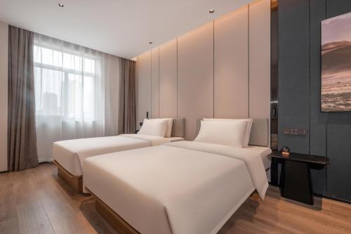 a hotel room with two beds and a window at Atour Hotel Jiaojiang Taizhou in Taizhou