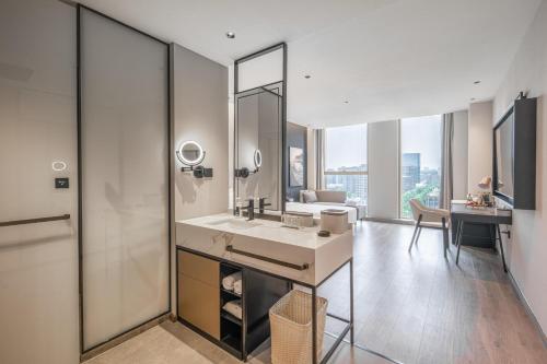 a bathroom with a sink and a vanity with a mirror at Atour Hotel Nantong Central South BRICS in Nantong