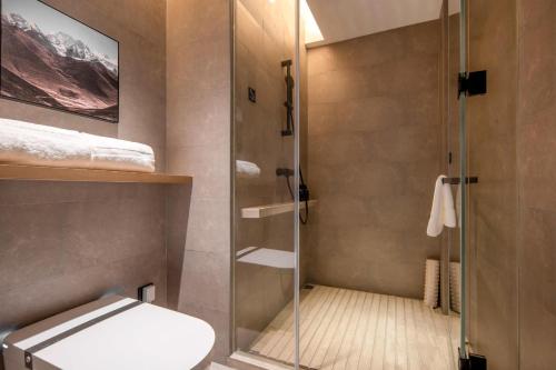 a bathroom with a glass shower with a toilet at Atour Hotel Jiaojiang Taizhou in Taizhou