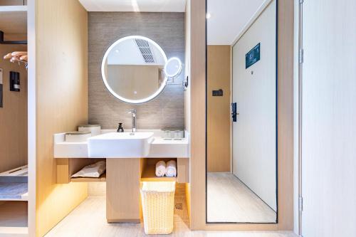 uma casa de banho com um lavatório e um espelho em Atour Hotel Xiaolan Zhongshan em Zhongshan