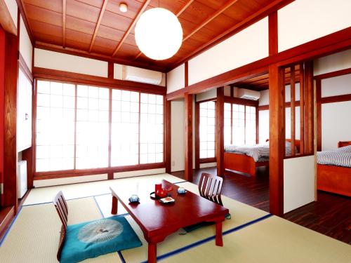 una habitación con mesa y sillas y un dormitorio en 富山県 よしのや旅館, en Nanto