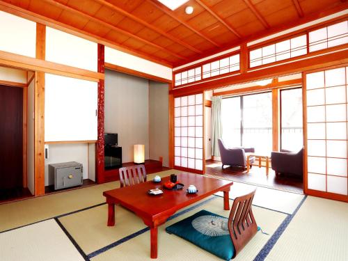 sala de estar con mesa y sillas en 富山県 よしのや旅館, en Nanto