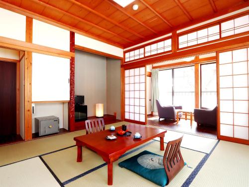 a living room with a table and chairs at Yoshinoya Ryokan in Nanto