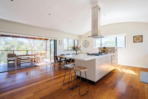 an open kitchen and dining room with a table and chairs at Alleura House Serene Bushland 4BR Families Groups in Leura