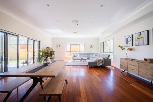 a living room with a couch and a table at Alleura House Serene Bushland 4BR Families Groups in Leura