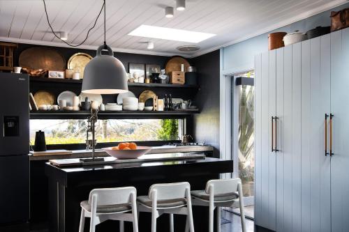 a kitchen with a black counter and white cabinets at Harts Lane Haus- outdoor entertainer, pet friendly in Daylesford