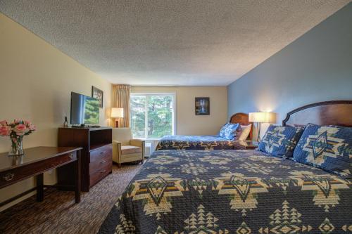 Habitación de hotel con cama y TV en Columbia Gorge Inn, en Cascade Locks