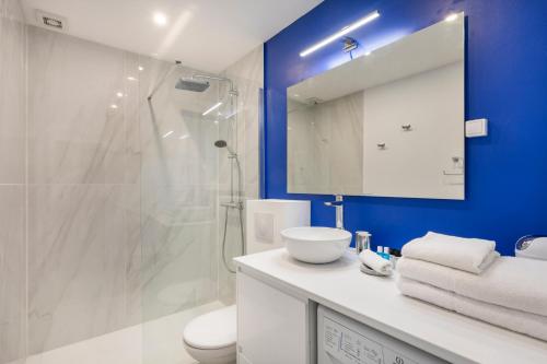 une salle de bain avec un lavabo blanc et une douche dans l'établissement BLUE LIGHT TERRACE - Nice Port, à Nice