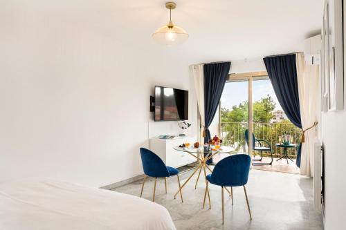 une chambre avec un lit, une table et des chaises dans l'établissement BLUE LIGHT TERRACE - Nice Port, à Nice