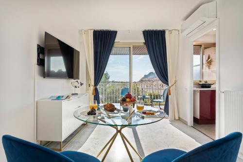 - un salon avec une table en verre et des chaises bleues dans l'établissement BLUE LIGHT TERRACE - Nice Port, à Nice