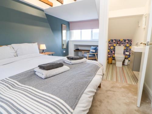 a bedroom with a bed with two towels on it at Cowrie Cottage in North Shields