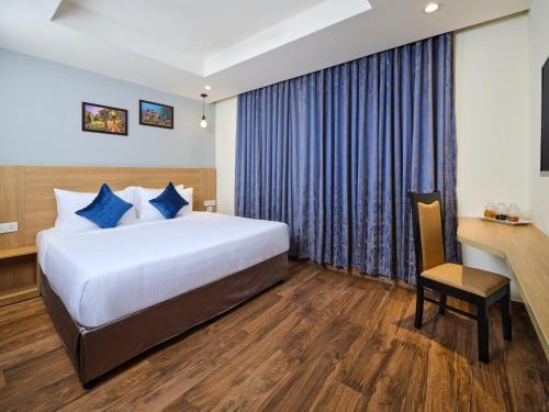 a hotel room with a bed and a desk at Essentia Premier Hotel Chennai OMR in Chennai