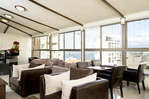 a waiting room with couches and tables and windows at Bliss 3000 Furnished Studios in Beirut