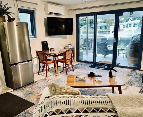 ein Wohnzimmer mit einem Kühlschrank und einem Tisch in der Unterkunft The Waterfront Apartment in Port Fairy