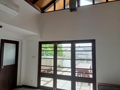 ein leeres Zimmer mit einer Tür und einem Balkon in der Unterkunft Villa Suyara Rooftop,,, in Panadura