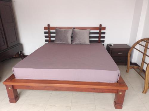 a bed in a bedroom with a wooden bed frame at Villa Suyara Rooftop,,, in Panadura