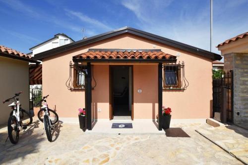 une petite maison avec un vélo garé devant elle dans l'établissement Deluxe Apartment Nono- Anex building, à Poreč
