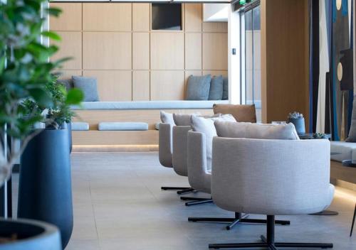 a row of white chairs in a waiting room at The Alex Monte Kastella, Santikos Collection in Piraeus