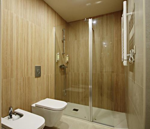 y baño con ducha, aseo y lavamanos. en BUTEKO HOUSE AL, en Miranda do Douro