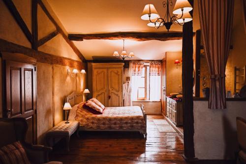 een slaapkamer met een bed en een bank in een kamer bij Demeure de la Carmine, sejour bien-etre d'exception, piscine, hammam, champagne in Mirepoix