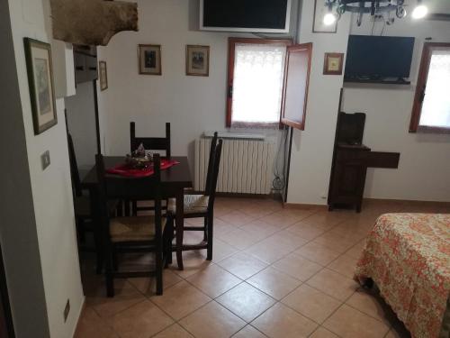 uma sala de jantar com uma mesa e cadeiras num quarto em La casina di Assisi em Assisi