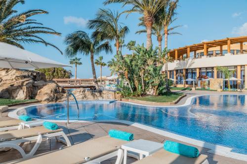 - une piscine dans un complexe avec des palmiers dans l'établissement Iberostar Playa Gaviotas All Inclusive, à Morro del Jable