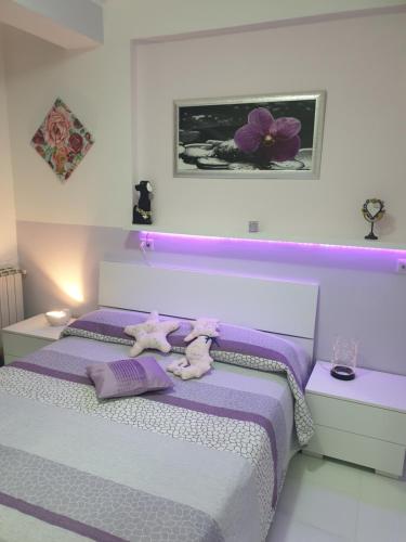 a bedroom with a purple bed with two stuffed animals on it at Le case di Grazia in Gaeta