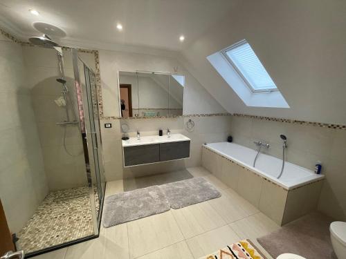 a bathroom with a shower and a tub and a sink at Sunny house in Suceava