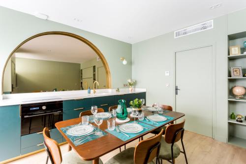 une salle à manger avec une table, des chaises et un miroir dans l'établissement Relais Cocorico 2 Bedrooms with AC, 2 bathrooms, 8 min Eiffel Tower, à Paris
