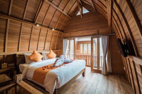 a bedroom with a bed in a room with wooden walls at Andi Beach House in Canggu