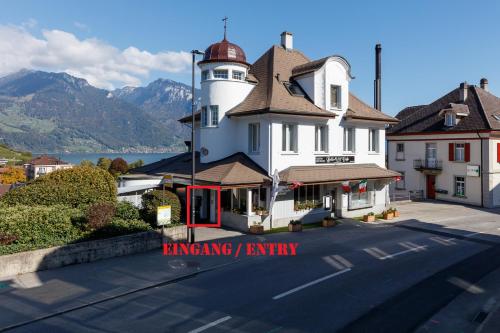a building with a lighthouse on the side of a street at BERG & BERG APARTMENTS - Spiez Self-Check-in in Spiez
