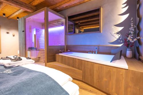 a bathroom with a tub and a bed in it at Teverone Suites & Wellness in Lamosano