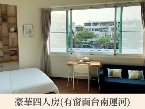 a bedroom with a bed and a desk and a window at New Color River in Tainan