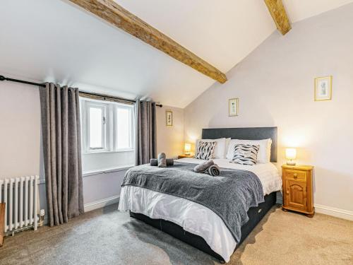 Un dormitorio con una cama grande y una ventana en Spinners Cottage en Keighley