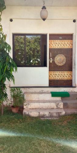 a front door of a house with stairs and a window at Hotel Kota kunj Heritage in Pushkar