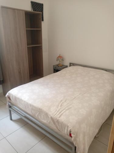 - un lit avec un drap blanc dans une chambre dans l'établissement T2 neuf Sète centre ville, à Sète