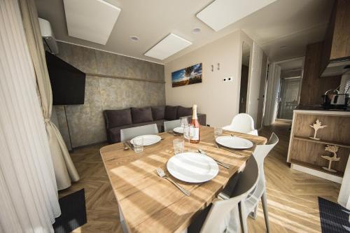 a dining room with a table and a couch at Sonnenthermen Chalets & Therme included - auch am An- & Abreisetag! in Lutzmannsburg