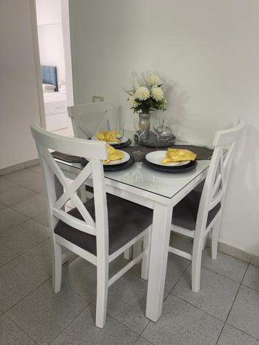 a dining room table with two chairs and a white table with plates at City Center Apartment - Neama Bay in Sharm El Sheikh