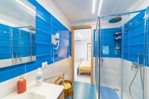 a blue bathroom with a shower and a sink at Alle 6 palme in Ercolano