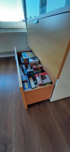 un tiroir avec des livres dans une armoire dans l'établissement FeWo Rohleder de 130m mit Garten 6Pers 2Bad, à Cottbus