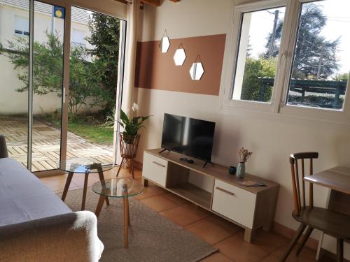 a living room with a flat screen tv on a table at Maisonnette de Charme à 10min de Fontainebleau in Héricy